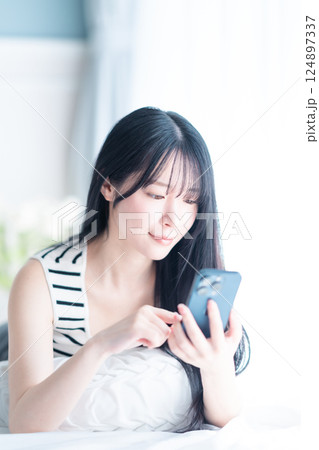 明るい部屋でインターネット検索をする一人暮らしの若い女性 124897337