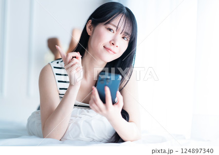 明るい部屋でインターネット検索をする一人暮らしの若い女性 124897340