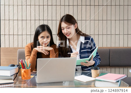 Educational Interaction and Study Goals. Two friends engaged in a focused study session for their academic objectives. 124897914