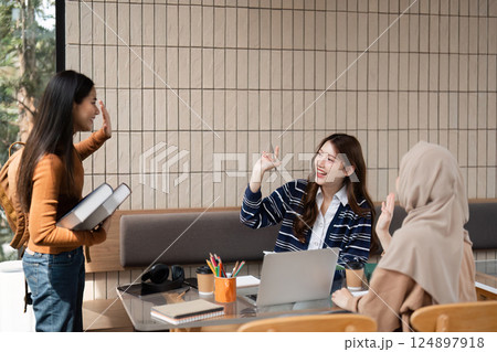 Greetings and Networking. Students exchanging greetings in a friendly study environment at a cafe. 124897918