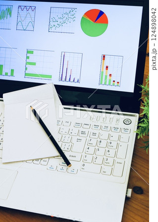 ビジネスイメージ　グラフとパソコン　チャート　デスクワーク　縦位置 124898042