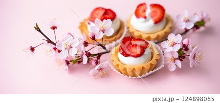 Delicious strawberry desserts with cherry blossoms on pink background 124898085