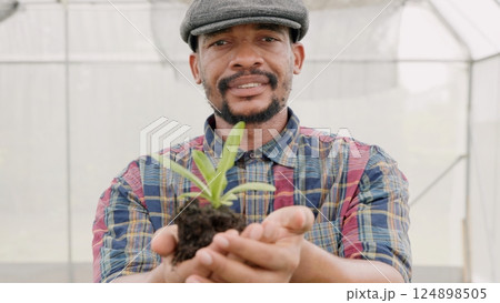 Confident farmer man showing compacted soil with children green lettuce, farming holding hand just taking from ground and lettuce, Agriculture farming 124898505