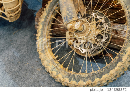 dirty off-road enduro motorcycle wheel. dirt motorcycle tire from off-road racing 124898872
