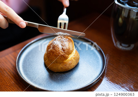 シュークリームを食べる手元 124900363