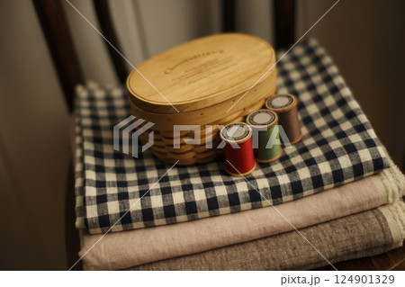 椅子の上の裁縫箱と色とりどりな糸と生地 椅子の上の裁縫箱と色とりどりな糸と生地 124901329