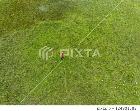 woman riding mountain bike on beautiful flowering grassland mountain top 124901388