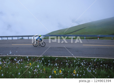 Riding mountain bike on grassland mountain trail 124901394