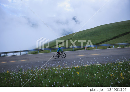 Riding mountain bike on grassland mountain trail Riding mountain bike on grassland mountain trail 124901395