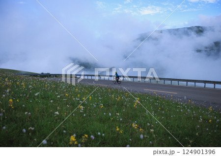 Riding mountain bike on grassland mountain trail 124901396