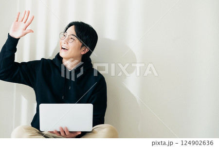壁際でパソコンを使う男性 124902636