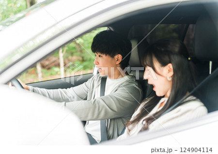 急ブレーキを踏む交通事故に遭いそうな男性ドライバーと恐怖で叫ぶ助手席の女性 124904114