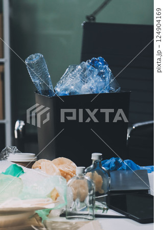 Close-up of female hands from a family collecting plastic waste and bottles from the ground. They wear gloves and focus on recycling to help reduce plastic pollution and protect the environment. 124904169