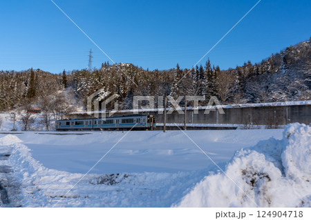 雪景色の中を走る大糸線の電車 124904718