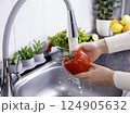 Woman hands washing a red bell pepper to prepare a fresh salad in the kitchen 124905632