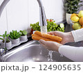 Woman hands washing fresh carrots in the kitchen 124905635