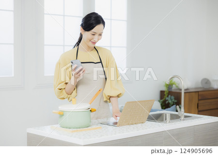 キッチンで料理をする女性 124905696