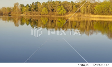 Large pond surrounded by trees and plants. Camping. Spring landscape. 124906542