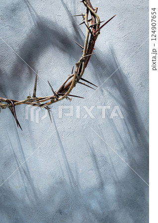 Crown of thorns projecting shadowy silhouette against textured gray surface, symbolizing spiritual pain and redemptive struggle good friday for Christian background, Easter concept 124907654