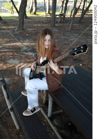 Girl Plays The Bass Instrument In The Countryside In Summer Girl Plays The Bass Instrument In The Countryside In Summer 124908042