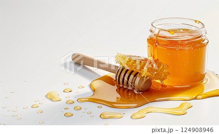 A spill of golden honey on a clean white surface 124908946