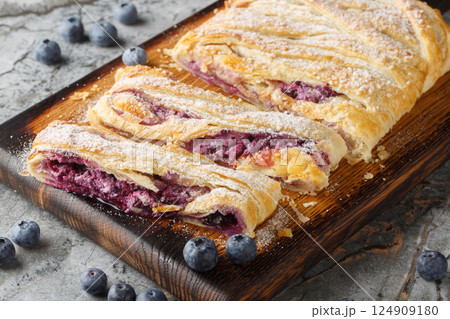 Delicious blueberry pie with fresh berries and patissiere cream close-up on a wooden board. Horizontal Delicious blueberry pie with fresh berries and patissiere cream close-up on a wooden board. Horizontal 124909180