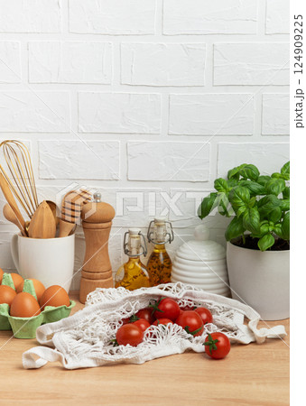 Cherry tomatoes, basil and eggs resting on kitchen counter, embodying healthy lifestyle Cherry tomatoes, basil and eggs resting on kitchen counter, embodying healthy lifestyle 124909225