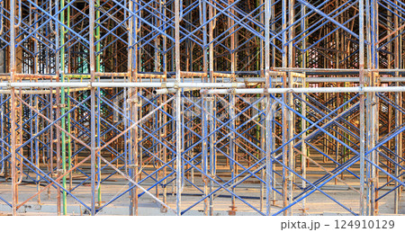 A large number of scaffoldings are used in large construction projects. Scaffolding for on construction site of the new building. 124910129