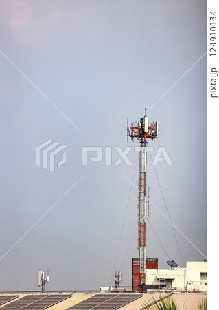 Wireless Communication Antenna pole, Mobile phone mast antenna pole on top of dilapidated building Wireless Communication Antenna pole, Mobile phone mast antenna pole on top of dilapidated building 124910134
