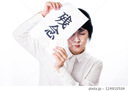 残念と書かれた紙を掲げ顔をしかめる中年女性 残念と書かれた紙を掲げ顔をしかめる中年女性 124910584