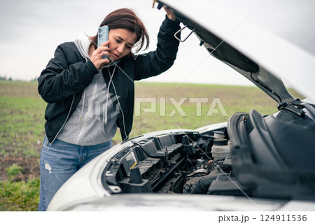 Female Driver With Broken Car On A Road Calls Tow Truck Female Driver With Broken Car On A Road Calls Tow Truck 124911536