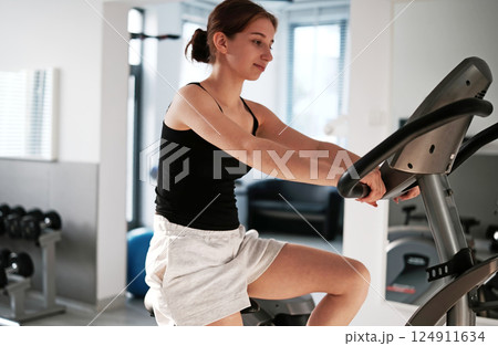 Girl Training With A Bike Trainer In The Gym, Focusing On Fitness And Health 124911634