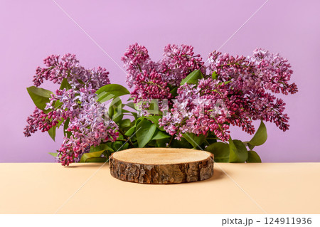 Wood slice podium and and blooming branches of maroon lilac on beige background. Concept scene stage showcase for new product, banner, promotion sale, cosmetic, presentation. Spring concept Wood slice podium and and blooming branches of maroon lilac on beige background. Concept scene stage showcase for new product, banner, promotion sale, cosmetic, presentation. Spring concept 124911936