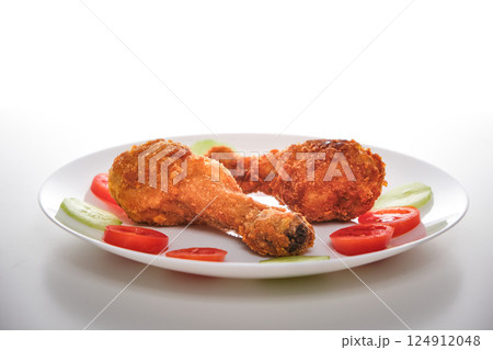 Two Fried Chicken Legs with Tomato and Cucumber 124912048