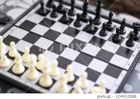 Closeup of a chess board with white and black pieces Closeup of a chess board with white and black pieces 124912086