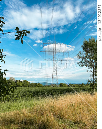 Tall power line tower is seen in the distance, with a clear blue sky above Tall power line tower is seen in the distance, with a clear blue sky above 124912871
