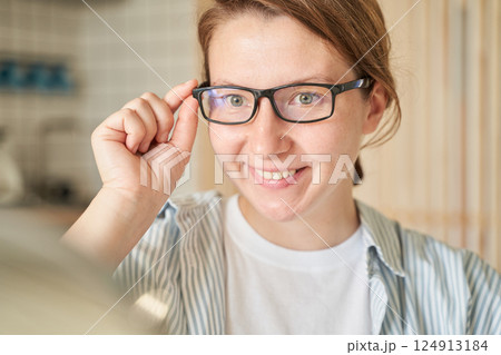 Caucasian female young adult smiling with glasses in home interior setting 124913184