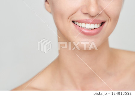 Close up of young caucasian female smiling with visible teeth and smooth skin Close up of young caucasian female smiling with visible teeth and smooth skin 124913552
