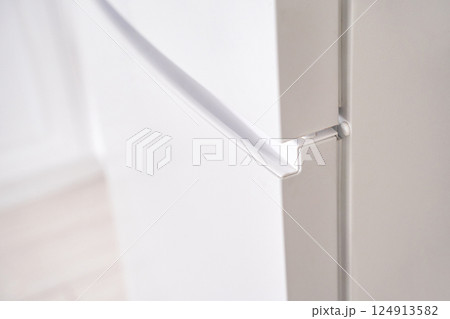 Close up of modern white refrigerator door with seamless handle design in bright Close up of modern white refrigerator door with seamless handle design in bright 124913582