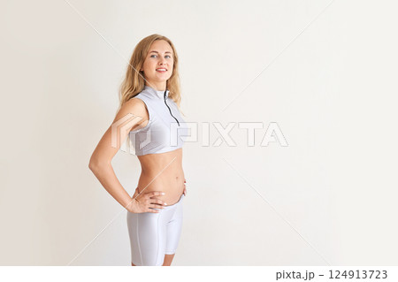 Fit young caucasian adult female in activewear posing confidently against Fit young caucasian adult female in activewear posing confidently against 124913723