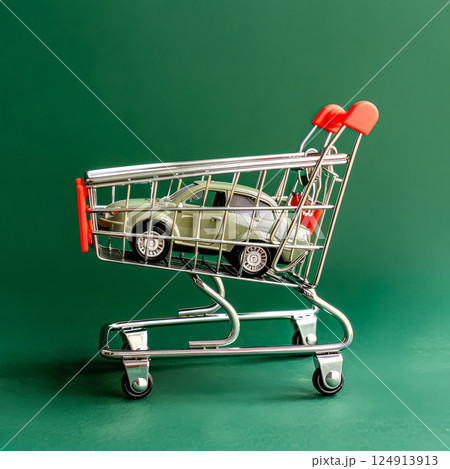 Toy car is sitting on a shopping cart. 124913913