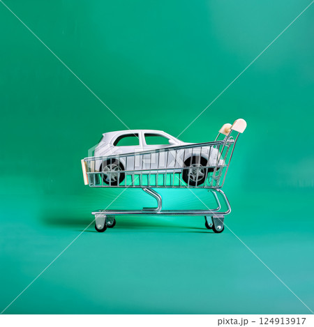 Toy car is sitting on a shopping cart. 124913917