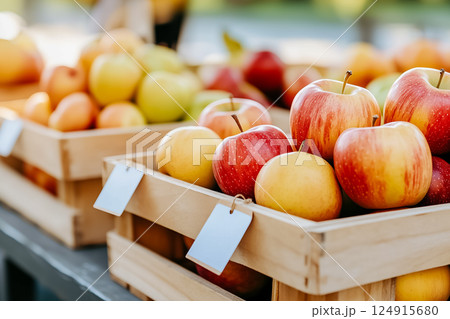 Fresh apples nestled in wooden crates, showcasing vibrant colors. Farmers market setting with sunlight illuminating the scene. Concept of local produce, healthy eating, fresh fruit. 124915680