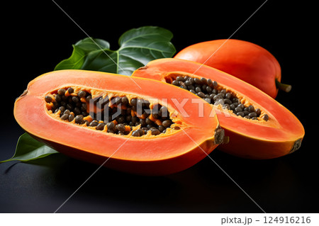 Two pieces of orange fruit with a green leaf in between. Two pieces of orange fruit with a green leaf in between. 124916216