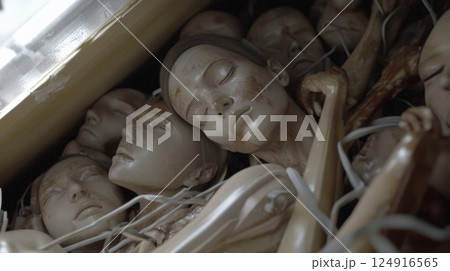 Surreal arrangement of lifelike mannequin faces in a haunting composition 124916565