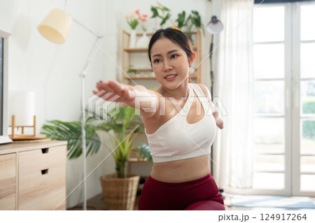 Empowerment and Movement. A woman performing a dynamic yoga pose, showcasing her strength and commitment to wellness. Empowerment and Movement. A woman performing a dynamic yoga pose, showcasing her strength and commitment to wellness. 124917264