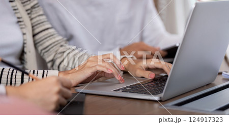 Collaboration and Engagement. Close-up of students actively typing and taking notes during a group study session. Collaboration and Engagement. Close-up of students actively typing and taking notes during a group study session. 124917323