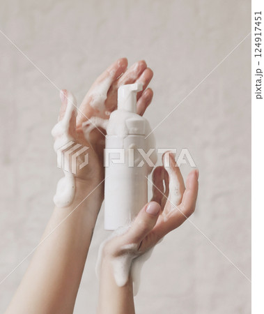 Woman washing hands with soap on white stone background 124917451