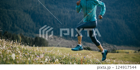 Woman ultramarathon runner running at forest and grassland mountain top Woman ultramarathon runner running at forest and grassland mountain top 124917544