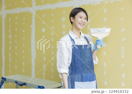 石膏ボードにパテをする女性　 124918152